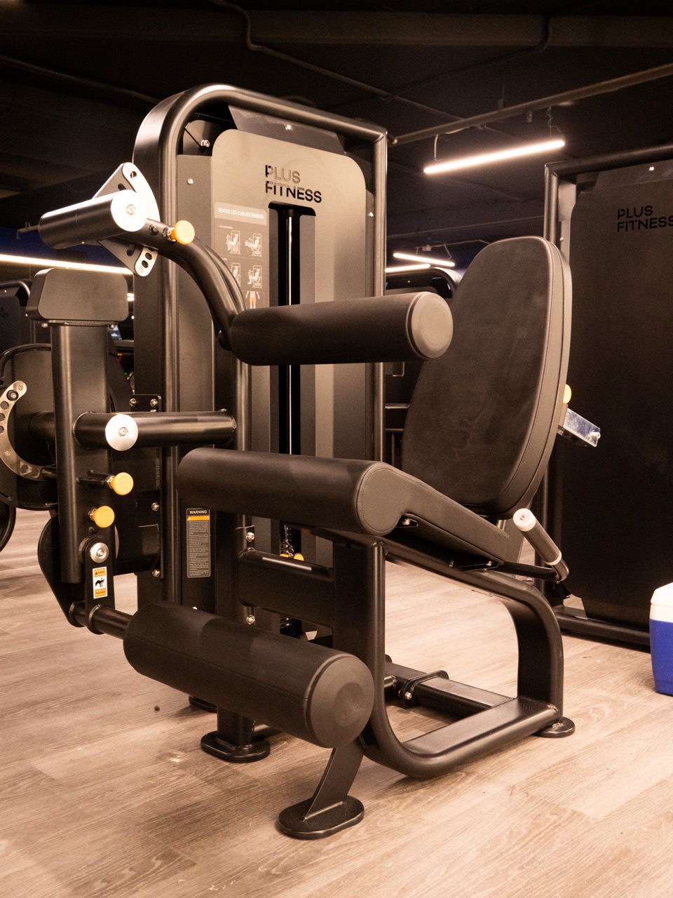 Plus Fitness branded pin-loaded leg machine