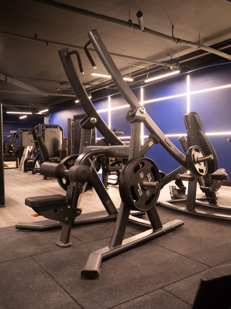 Plus Fitness Miranda — SHUA plate-loaded strength floor with blue neon lighting